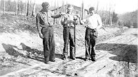 Three enrollees of the camp about 1938. In the middle is Harold Courtney holding up two dead rattle snakes caught in camp. The others are unidentified. Reference: "Written on the Land"