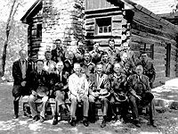 This group of
                  dignitaries came to recognize the men of Camp Morgan
                  and are pictured in front of one the park cabins built
                  by Co 1523 in the 1930's. The cabin's rugged
                  durability is symbolic strength of the CCC high
                  standards. IT WAS MADE TO LAST! Third from the right
                  in the front row is Robert Fechner, the national
                  director of the CCC. The scene is at the new Cacapon
                  State Park, near Berkeley Springs, WV shortly after
                  the park was opened in July,1937. (source: Written on
                  the Land")