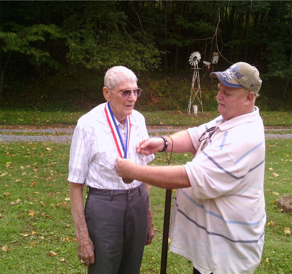 Mr. Doug Sparks, West Virginia State CCC Museum Rep, of Clarksburg places CCC Hall of Fame medallion on Mr. Teddy Davis during ceremonies in Lewis County.